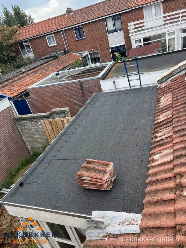 Plat dak aanbouw met bitumen naast schuin pannendak in Hattem