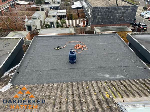 Plat dak met nieuwe bitumen dakbedekking en brandgereedschap in Hattem