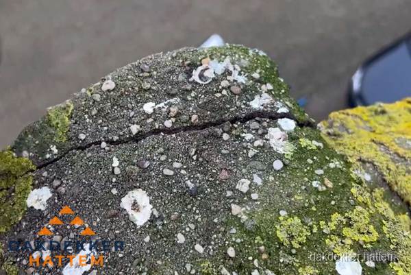 Beschadigde en verweerde nokvorst met scheuren en mos in Hattem Beschadigde en verweerde nokvorst met scheuren en mos in Hattem