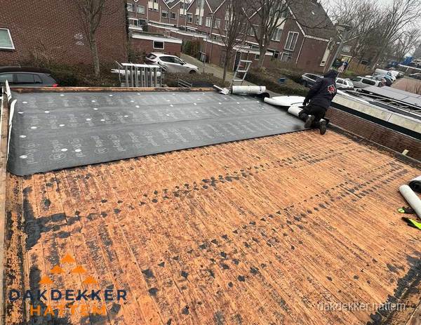 Dakdekker legt onderlaag op plat dak met houten constructie in Hattem